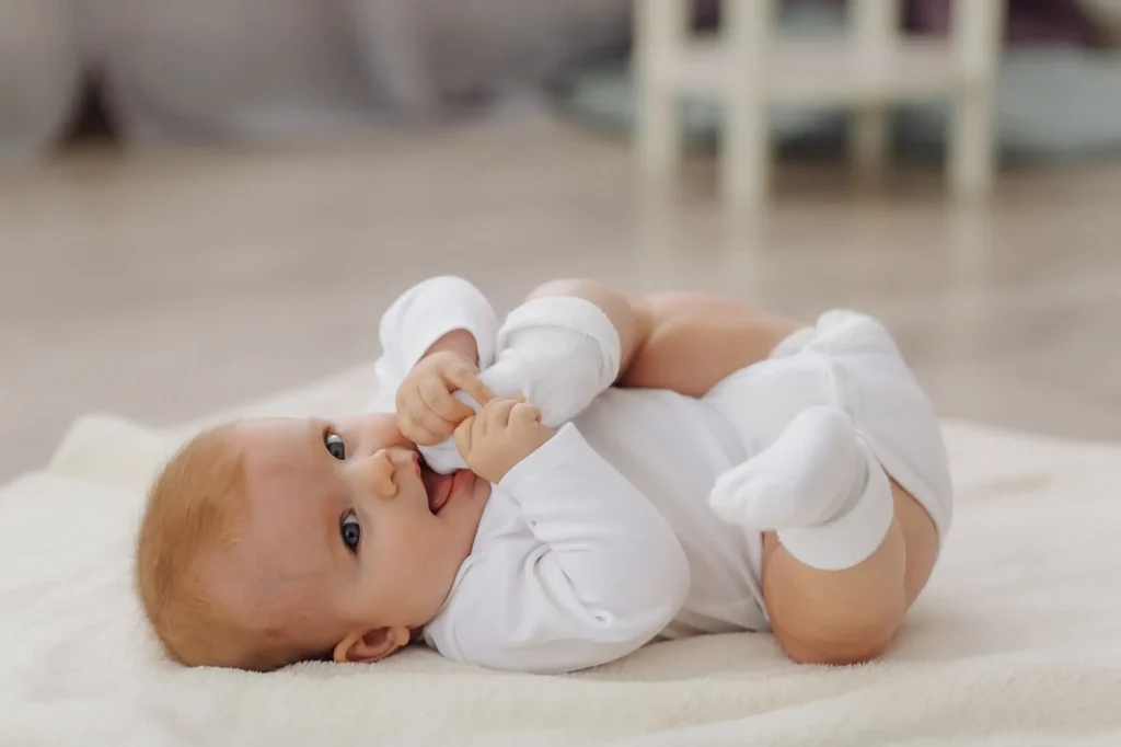 A baby playfully holding its feet, representing comfort and care at The Baby Gear Land.