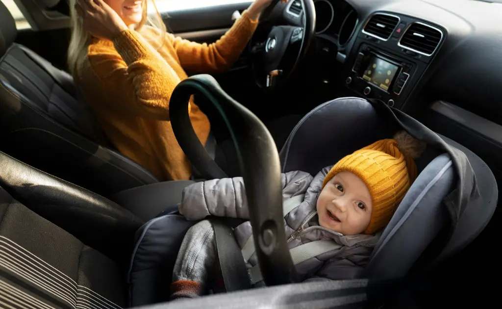 A baby safely secured in an infant car seat.