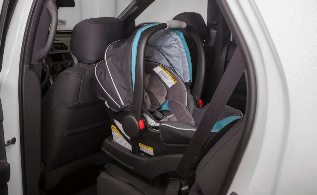 Infant car seat securely installed in a vehicle using a seat belt, ensuring proper safety measures.
