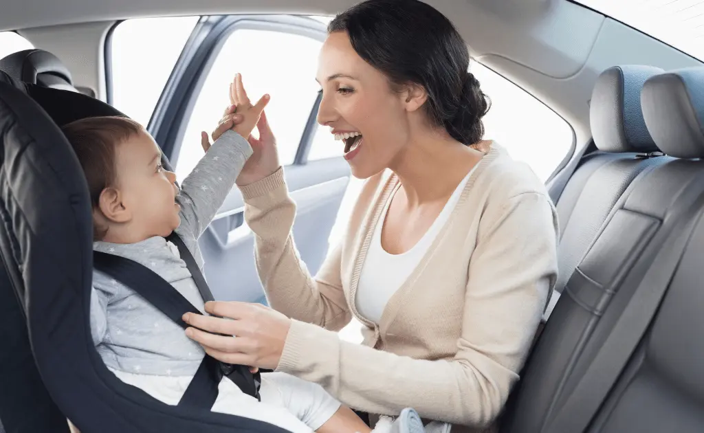 A joyful moment between a mother and her baby secured in a rear-facing convertible car seat set up.