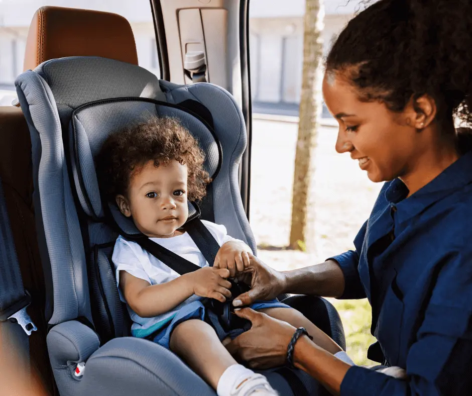 A mother checking for proper harness fit after installing a combination car seat.