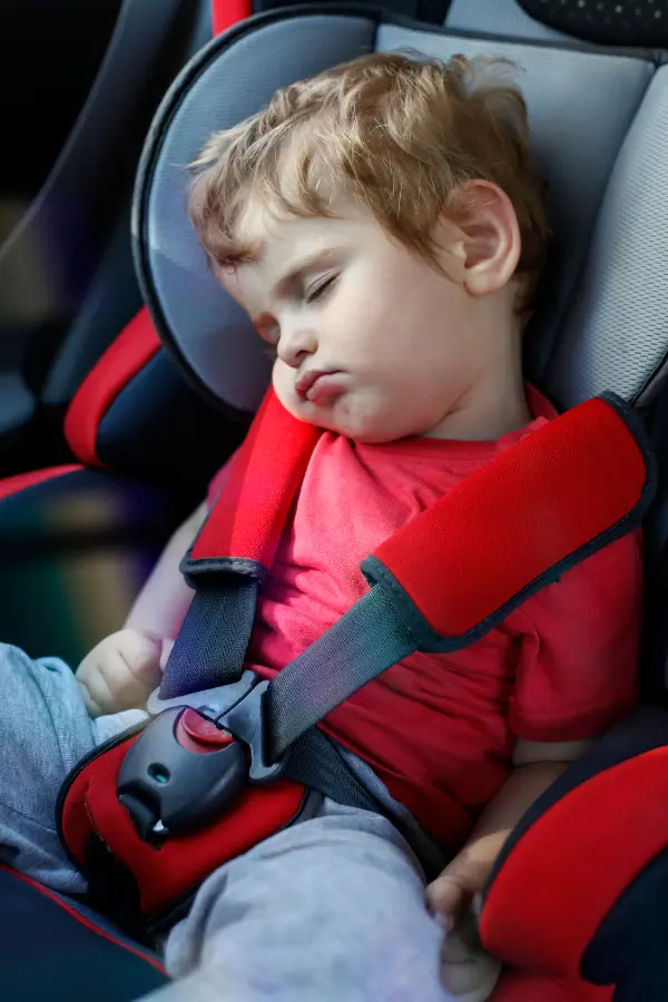 A child secured with a 5-point harness in combination car seat.