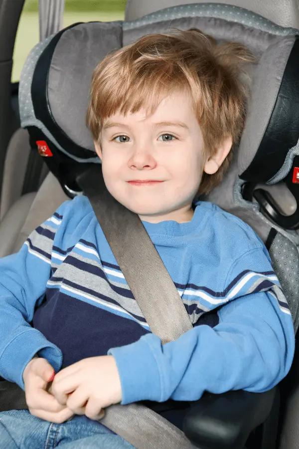 A child secured with a lap and shoulder belts in the booster mode of a combination car seat.