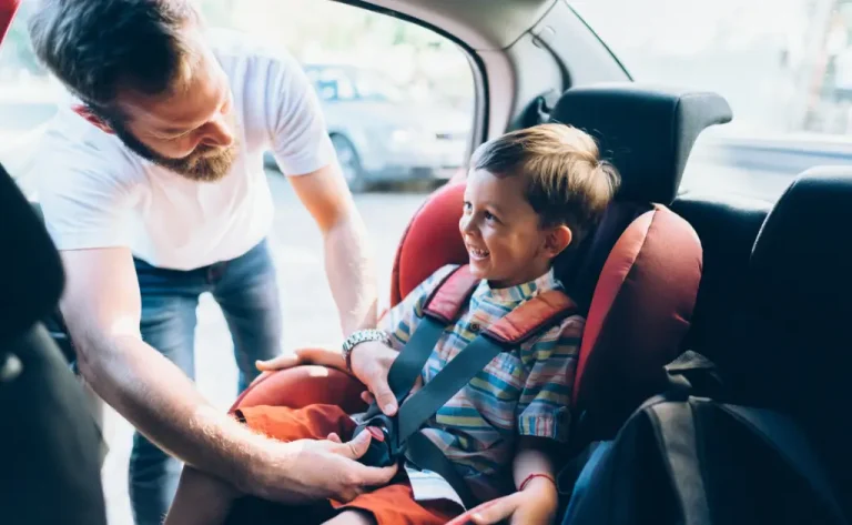 Dad securing toddler in a combination car seat, best for 2-in-1 safety and saving.