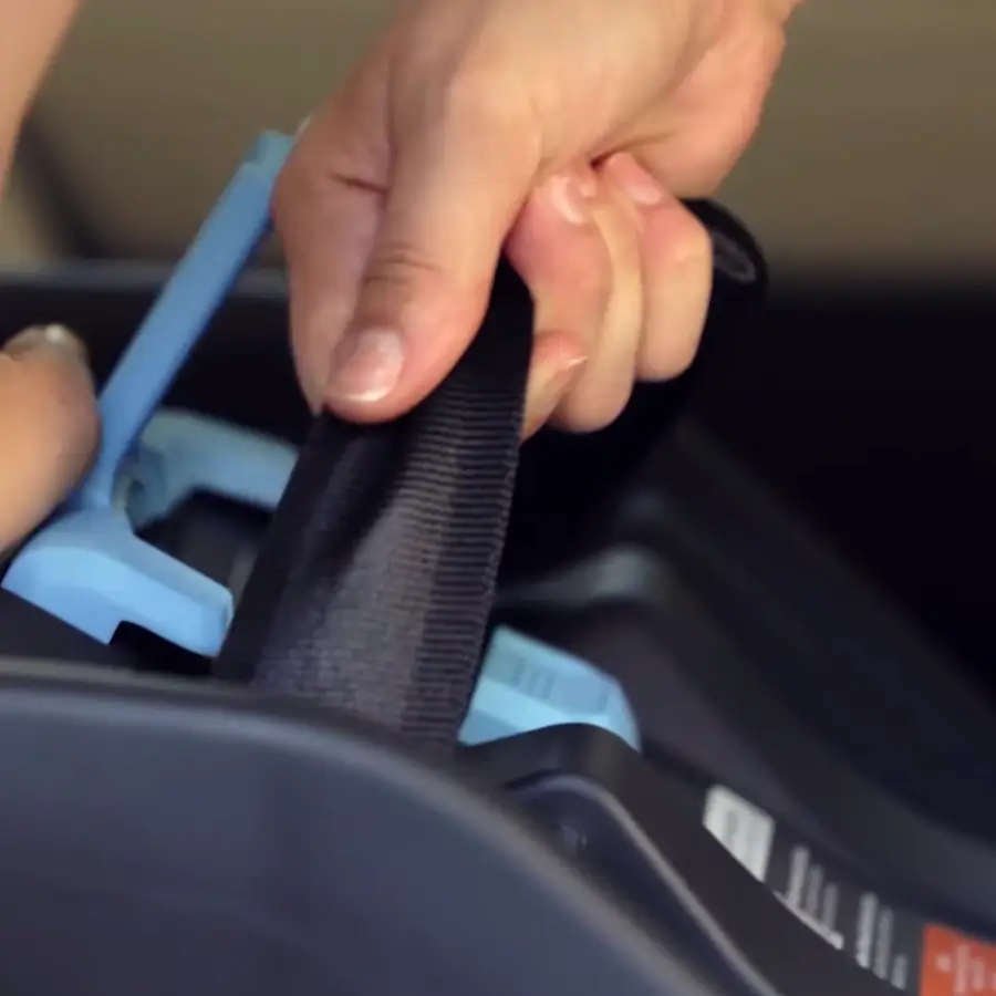 Seat belt path shown in the base of an infant car seat for proper installation setup.