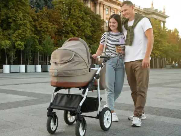 Parents walking with a modern baby stroller outdoors
